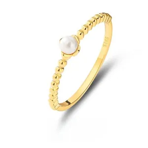 Dettaglio macro dell'anello di perle in argento S925 dorato con trama a sfere e marchio