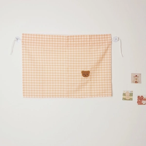 Detail of beige plaid cotton car curtain featuring a cute brown bear embroidery motif