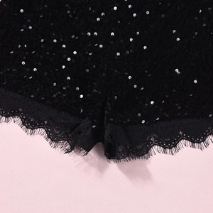 Détail macro du tissu à paillettes noires et de l'ourlet en dentelle de cils fins