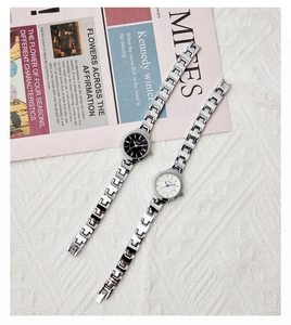 Detail view of silver alloy bracelet watches with black and white crystal-set dials