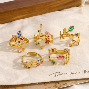 Detailed close-up of five adjustable 18K gold-plated rings with colorful zircon leaves
