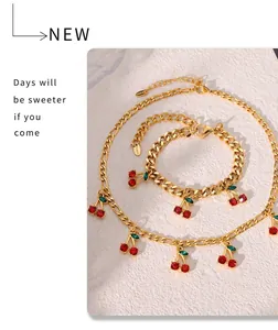 Detail of gold chain necklace and bracelet set with red crystal cherry charms