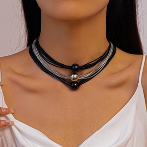 Detail of multi-layer black cord and silver snake chain necklace with beaded pendant