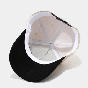 Two-tone trucker hat with black brim and beige body showing interior structure and sweatband