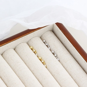Macro shot of silver and gold screw back chain earrings with marquise-cut zircons