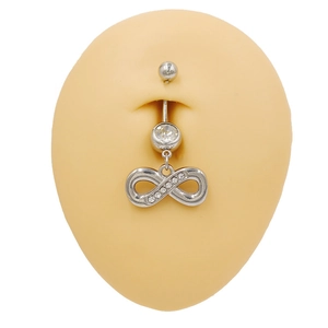 Détail du piercing de nombril symbole infini avec zircons blancs sur modèle de ventre