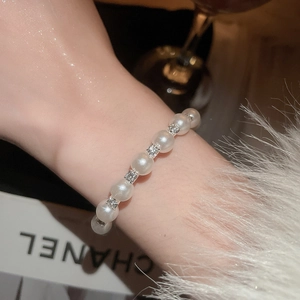 Detail of elegant double-layer pearl bracelet with crystal-studded square spacers