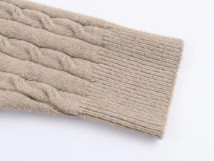 Macro shot of beige cable knit texture and elastic ribbed cuffs on the sweater