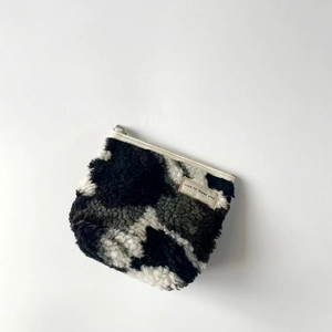Detail of plush cow print coin purse featuring fuzzy texture and nice to meet you label