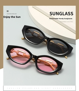 Close-up of vintage cat-eye sunglasses with gold metal chain arms and polarized lenses