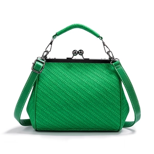 Detail of green PU leather handbag featuring woven texture and metal frame clasp closure