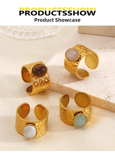 Detail of four vintage hammered gold rings with oval gemstones in various colors