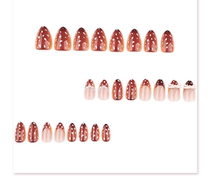 Détail de faux ongles amande marron avec pois blancs, perles et nœuds roses en 3D