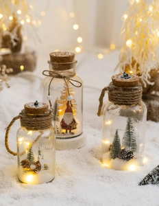 Close-up of glowing glass Christmas bottle with LED lights and festive micro landscape