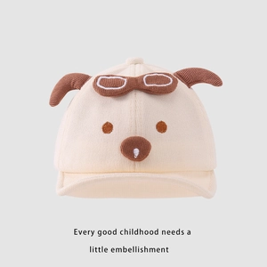 Detailed close-up of baby beige knit cap with dog ears and decorative goggles
