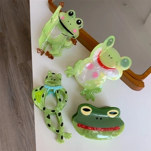 Detail von vier grünen Frosch-Haarklammern mit Marmortextur aus Acetat-Material