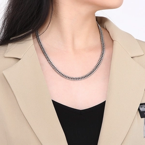Détail d'un collier à maille gourmette en acier titane argenté porté par un mannequin