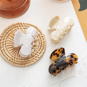 Detailed view of acetate hair claws in marble, cream, and tortoiseshell patterns