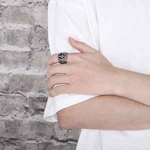 Close-up of retro punk stainless steel cross ring worn on finger by a male model
