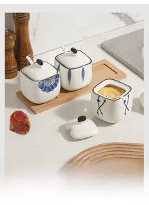 Detailed macro view of three Japanese ceramic seasoning jars with blue underglaze on wood tray