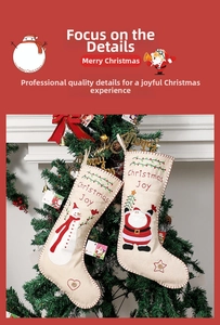 Detail of embroidered Christmas Joy stockings with Santa and snowman on burlap fabric