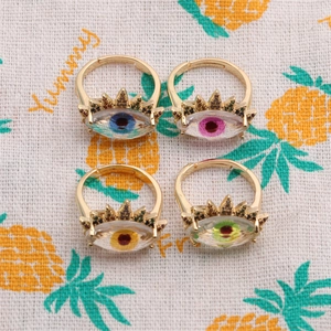 Set of four gold evil eye rings with colorful zircon inlays shown in a macro detail view