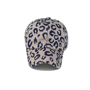 Detail of leopard print knitted baseball cap in beige with navy spots and warm texture