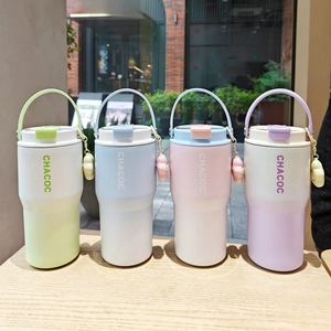 Detail of four colorful gradient vacuum insulated mugs with ring handles on wooden surface