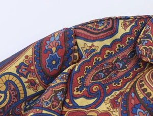 Gros plan sur le motif paisley complexe et la texture satinée soyeuse du pyjama