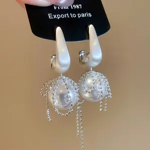 Elegant silver bow earrings with large white pearls and tassel bead chains in retro style