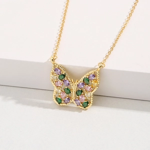 Gros plan détaillé du pendentif papillon doré avec des pierres précieuses multicolores
