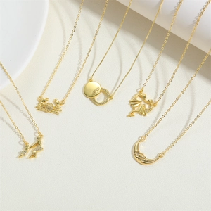 Detailed view of five gold crab and celestial pendant necklaces with zircon inlay
