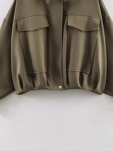 Detailed view of army green cropped bomber jacket with lapel collar and golden snap button