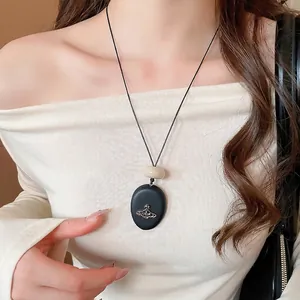 Vintage acrylic Saturn pebble pendant necklace with minimalist cords and retro beads