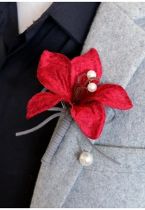 Detail of red velvet flower boutonniere with pearls on a grey wool suit lapel