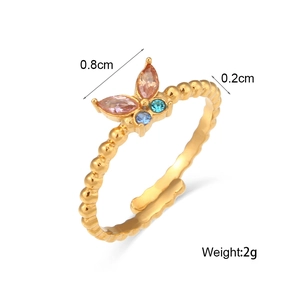 Verstellbarer goldener Schmetterlingsring mit rosa und blauen Zirkonsteinen auf weiß