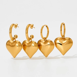 Detailed view of four golden heart-shaped hoop earrings with polished mirror finish