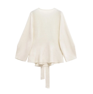 Detail of knit sweater showing ruffled peplum hem and matching waist belt tie