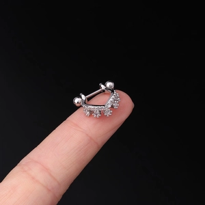 Macro shot of 20G stainless steel cartilage stud with cubic zirconia on a fingertip