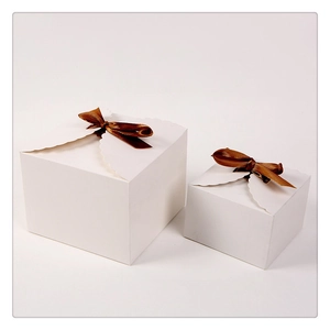 Minimalist white cardboard gift box with brown ribbon bow on a clean white background