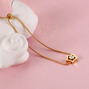 Detail of adjustable gold star bracelet featuring a central sparkling diamond setting