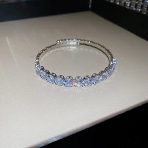Detail shot of shimmering zircon open bangle with close-up on sparkling stone settings