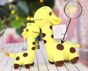 Detail of two giraffe plush toys with brown spots and suction cups on plaid fabric