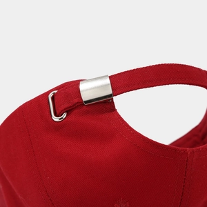 Detail of red cotton twill baseball cap with adjustable silver metal buckle at the back