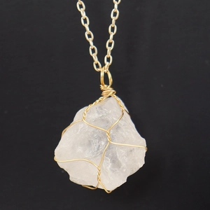 Macro detail of natural white crystal pendant with handmade gold wire wrapping
