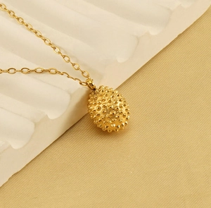 Macro shot of 18k gold plated durian pendant with realistic shell texture on necklace