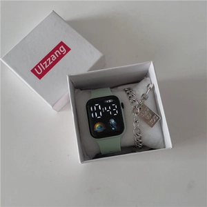 Macro detail of mint green LED digital sports watch with silver chain bracelet in box