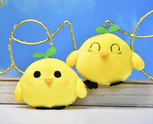 Close-up detail of yellow plush chick keychains featuring green sprouts and metal bead chains