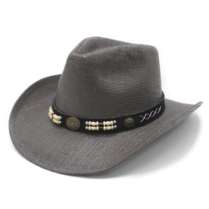 Detail of dark grey western straw cowboy hat with beaded band and metallic accents