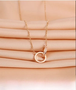 Detail of rose gold double interlocking rings necklace with shimmering cubic zirconia